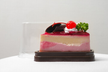a piece of strawberry jelly cheesecake in the take away plastic box - 402524532