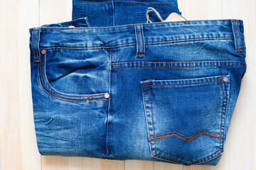 New jeans pants on wooden background