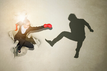 Businesswoman punching rival through a torn paper