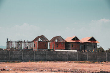 Fototapeta na wymiar Rows of houses that are under construction on an arid and barren land 