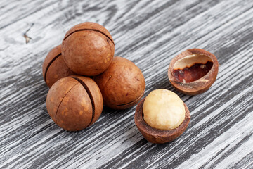 Macadamia nuts on black wooden table. Close-up.
