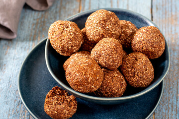 Chocolate coconuts. Chocolate balls with coconut. Chocolate candies or cookies with coconut, cinnamon and powdered sugar