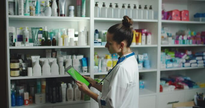 Pharmacist girl use tablet pad computer for check stock of phamacy in her drugstore, this image can use for hospital, clinic, lab and internet concept. High quality 4k footage