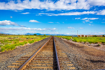 Fototapeta na wymiar Train rails converge far on the horizon