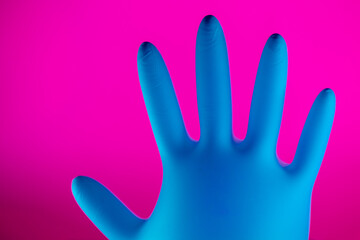 Latex surgical or medical glove . New Corona virus infection (novel corona virus disease) background. Pandemic panic concept. Pink Background