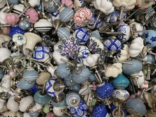 Assortment of Porcelain Cupboard Knobs of Blue, White and Grey  - Closeup of assorted hand-painted blue, white and grey porcelain cabinet pulls.
