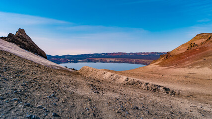 Panoramic view over Icelandic landscape of colorful volcanic caldera Askja, in the middle of volcanic desert in Highlands, with red, turquoise volcano soil and blue sky, Iceland