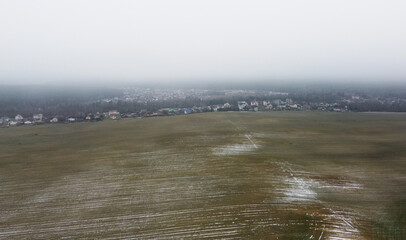 Top view of snowy agro field on foggy evening