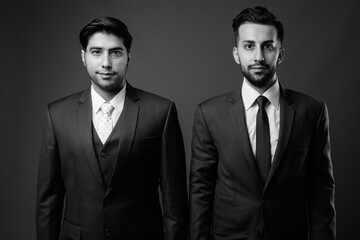 Studio shot of young handsome Iranian brothers together shot in black and white