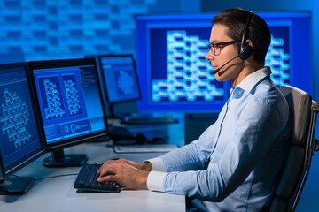 Call-center worker is speaking with the client by headset. Workplace of the professional support...