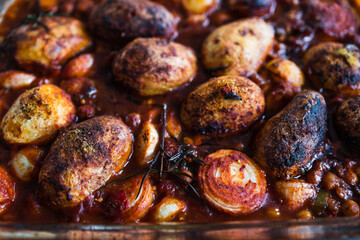 plant-based food, vegan potato and onion roast with chickpeas tomato sauce and herbs