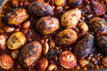 plant-based food, vegan potato and onion roast with chickpeas tomato sauce and herbs