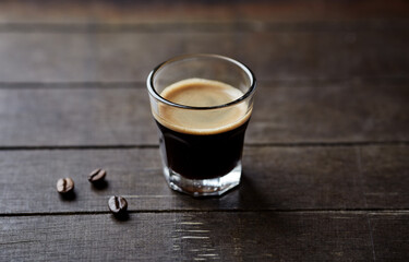 Coffee in glass cup on rustic wooden background. Close up.	