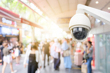 Modern public CCTV camera with blur crowd and shopping plaza background. Recording cameras for...