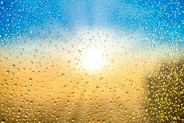 Obraz premium Beautiful sunset through a spattered glass with water rain drops