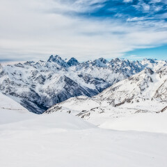 Snow blue mountains in clouds. Winter ski resort
