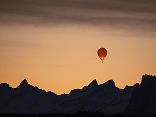 Hot air balloon over the mountains at sunrise