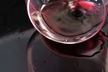 Glass of red dry wine spilled