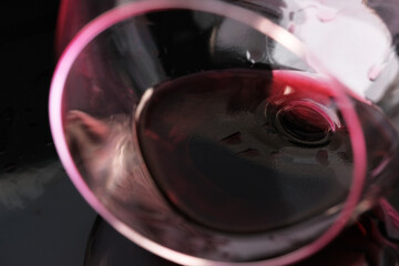 Glass of red dry wine spilled