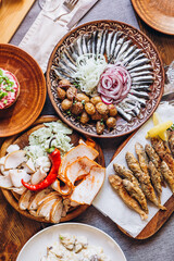 home wooden table covered with plates with various delicious dishes in the Slavic style: sourdough, salted and fried fish, potatoes, fried meat and salads