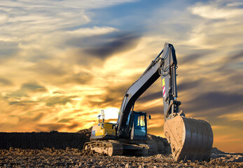 Excavator working on earthmoving at open pit mining on amazing sunset background. Backhoe digs sand...