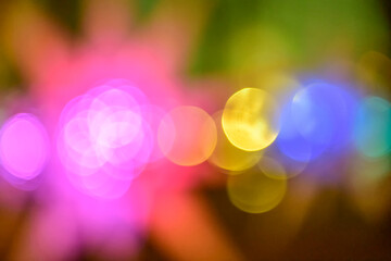 Multicolored holiday lights in defocus. Blurred abstract illuminate decorative lights with bokeh in night background.