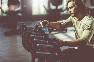 Fitness staff cleaning exercise machines alcohol sanitizer spray at the gym. preventive disease of...