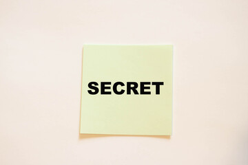 SECRET on square office paper on a white table.