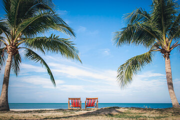 Two Beach Chairs between palm trees at the beach during a summer vacation-Vacation concept 