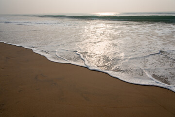 Foamy water from the sea on the shore in a winter morning.