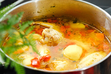 Soup with poultry, potatoes and greenery.  saucepan with soup