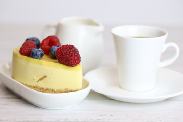 light cake with raspberries and blueberries and a cup of coffee, pleasant light breakfast