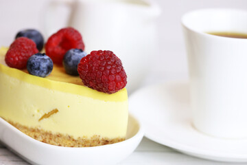 light cake with raspberries and blueberries and a cup of coffee, pleasant light breakfast