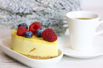 light cake with raspberries and blueberries and a cup of coffee, pleasant light breakfast