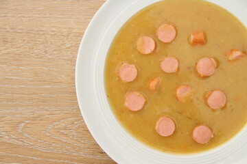 fresh potato soup with viennese sausages on a wooden board