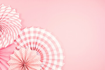 Festive party background with pink paper circle fans over pastel background. Festival, birthday, baby shower decoration