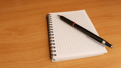 Pen and notepad on wooden desk. Education concept.
