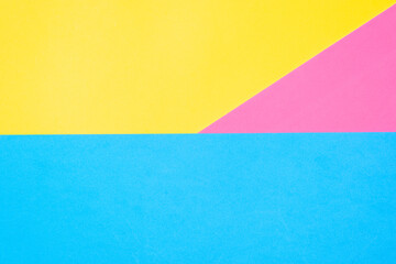 Fototapeta premium Multicolored paper background. Yellow pink and blue geometric backdrop. Three colors, copy space