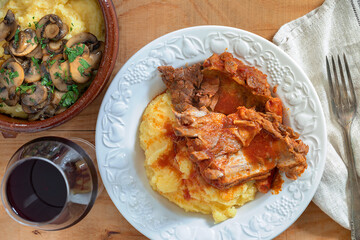 Traditional polenta with meat, mushroom and a glass of red wine.