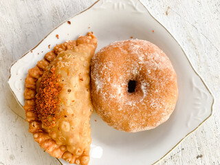 donut sugar and pastel is kind of indonesian snack for breakfast. served on a white plate isolated on wooden table.