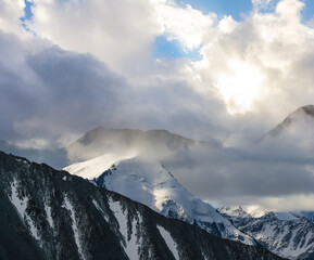 snowbound mountain chain in the dense clouds, natural travel background
