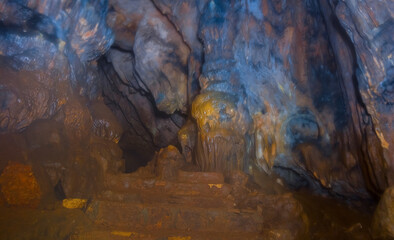 small cave in the mount with varicoloured stalagmite