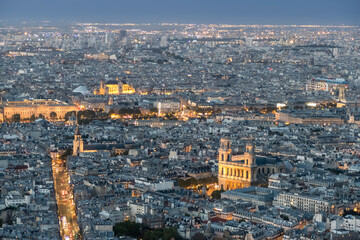 Naklejka premium Aerial view of Paris at twilight with the city illuminated