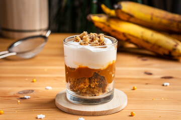 Fresh organic homemade baked bakery banana trifle layer parfait with brown sugar caramel white milk butter cream crust crumble topping and very ripe bananas bread loaf slice for cafe sweet desserts