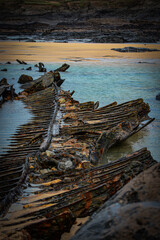Shipwreck on beach uncovered by tide