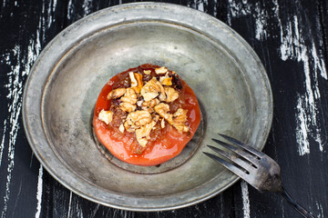 quince dessert with walnuts in a metal plate