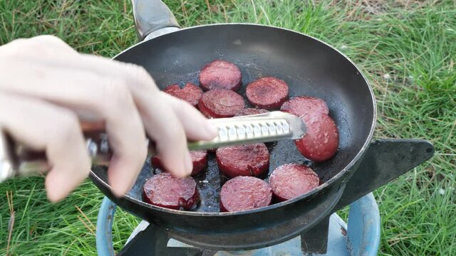 lady cooking frying sucuk meat outdoors  cooking food