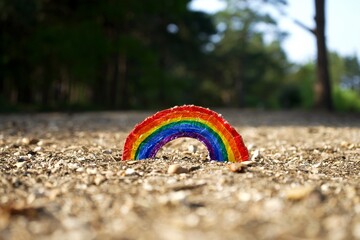 Kids arts and crafts rainbow on a gravel path. NHS rainbow tribute created by children during the...