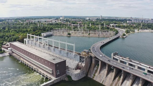 The beautiful river is surrounded by green and fresh vegetation in the city. Dnieper hydroelectric power station in Zaporozhye