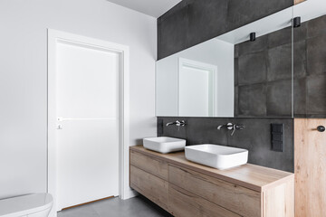 Double sinks in elegant white, concrete and wooden bathroom interior